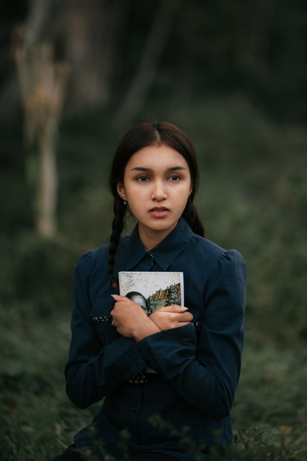 a young woman holding a book in her hands