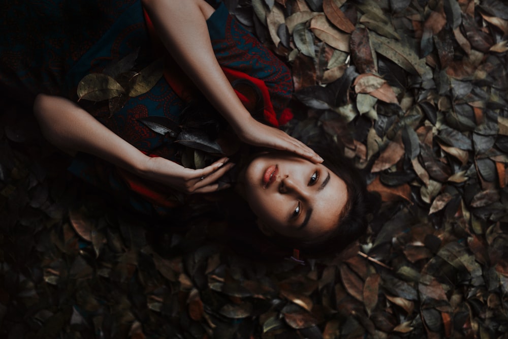 a woman laying on a pile of leaves