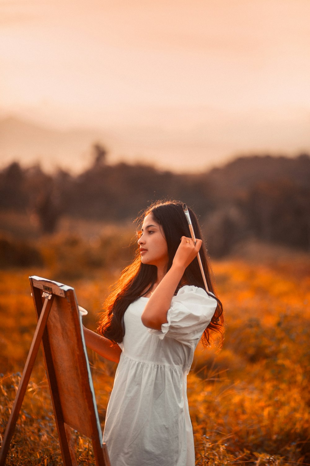 a woman in a white dress is holding a brush