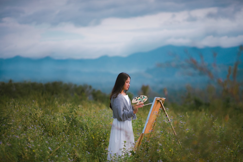 a woman in a white dress holding a plate of food