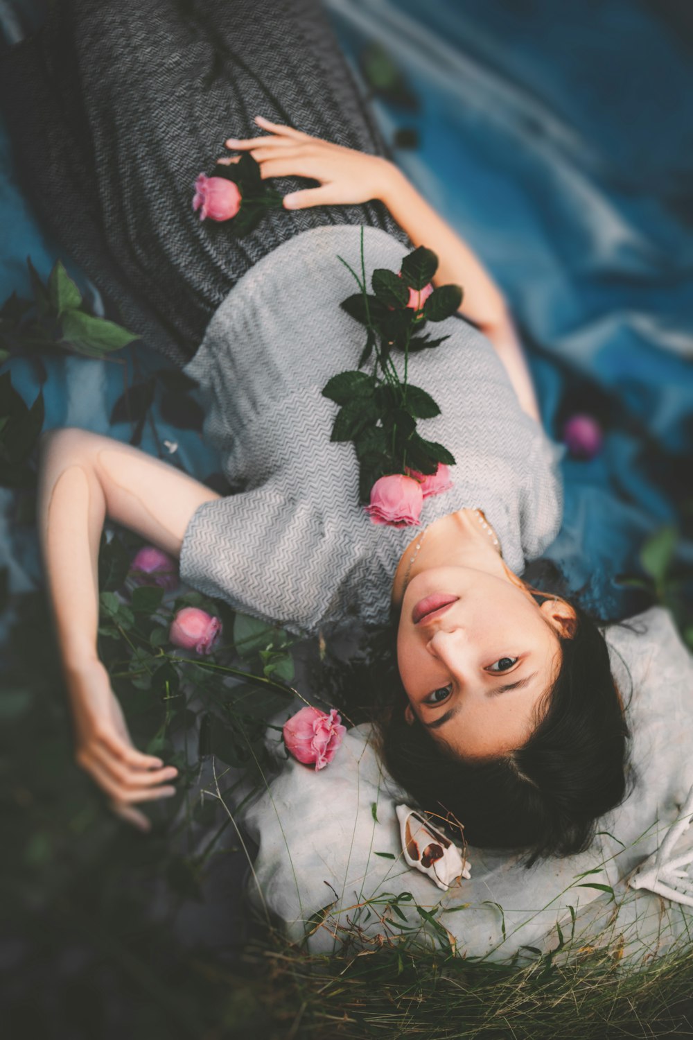 a woman laying on the ground surrounded by flowers