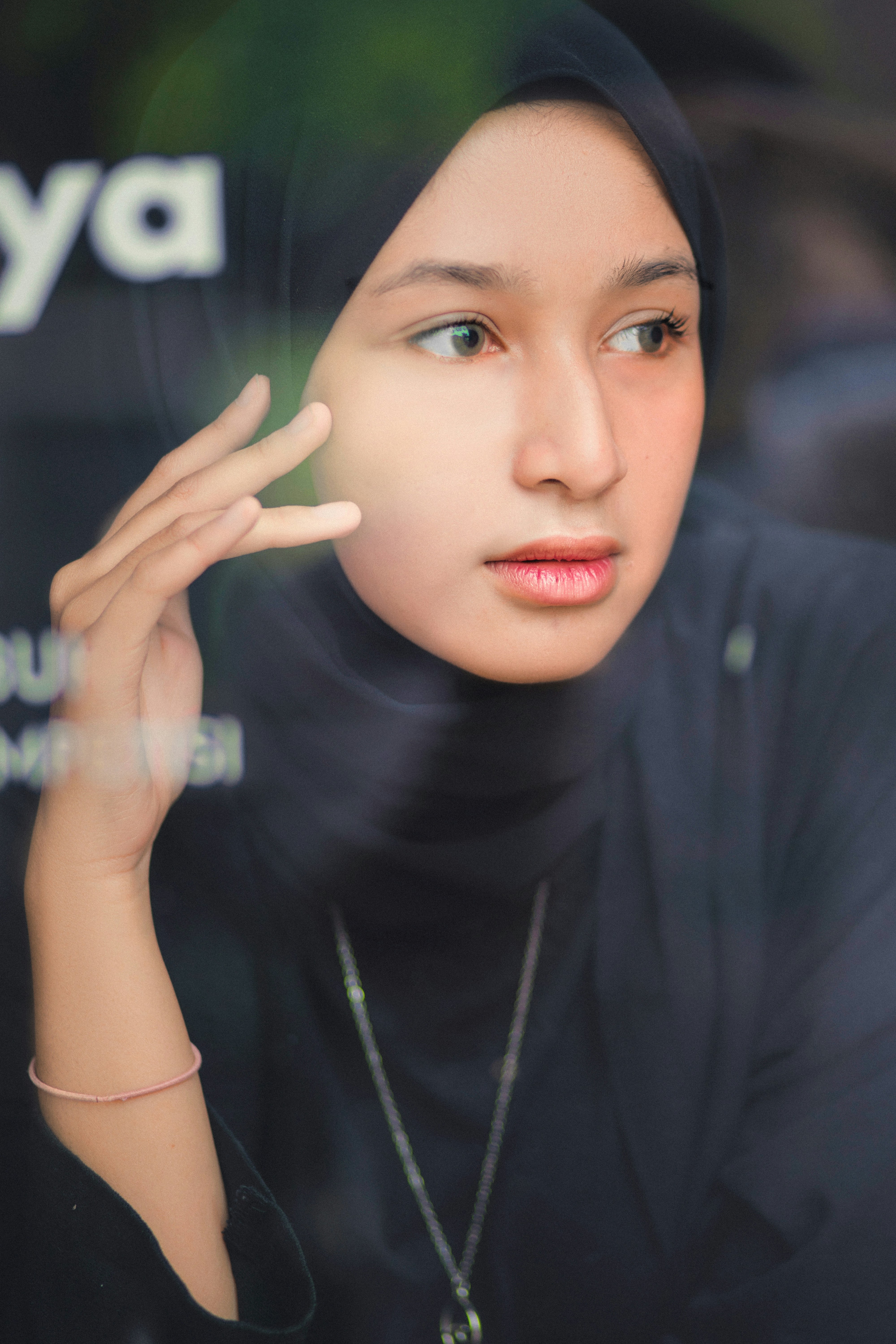 Seorang wanita berjilbab melihat ke luar jendela