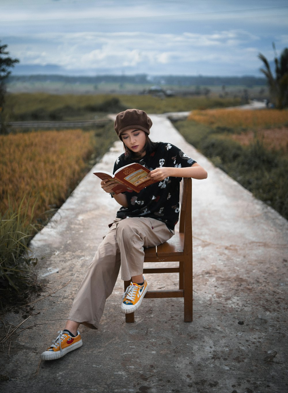 a boy sitting on a chair reading a book