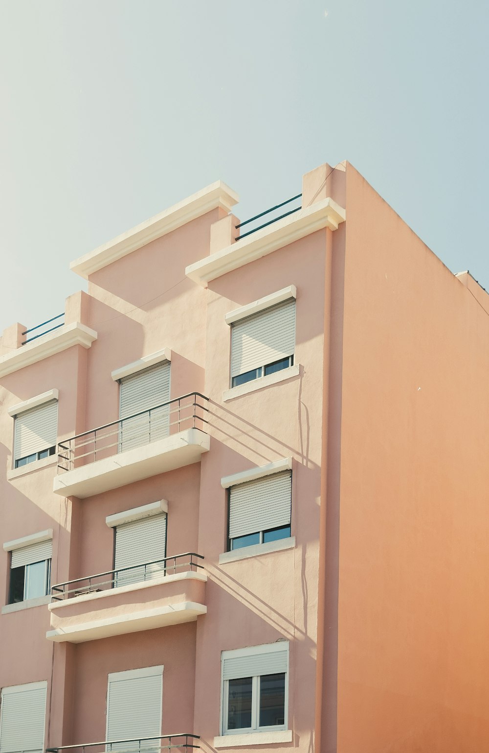 a pink building with balconies and balconies on the balconies