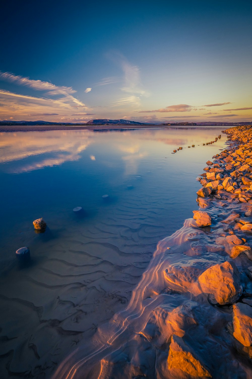 un cuerpo de agua rodeado de rocas y arena