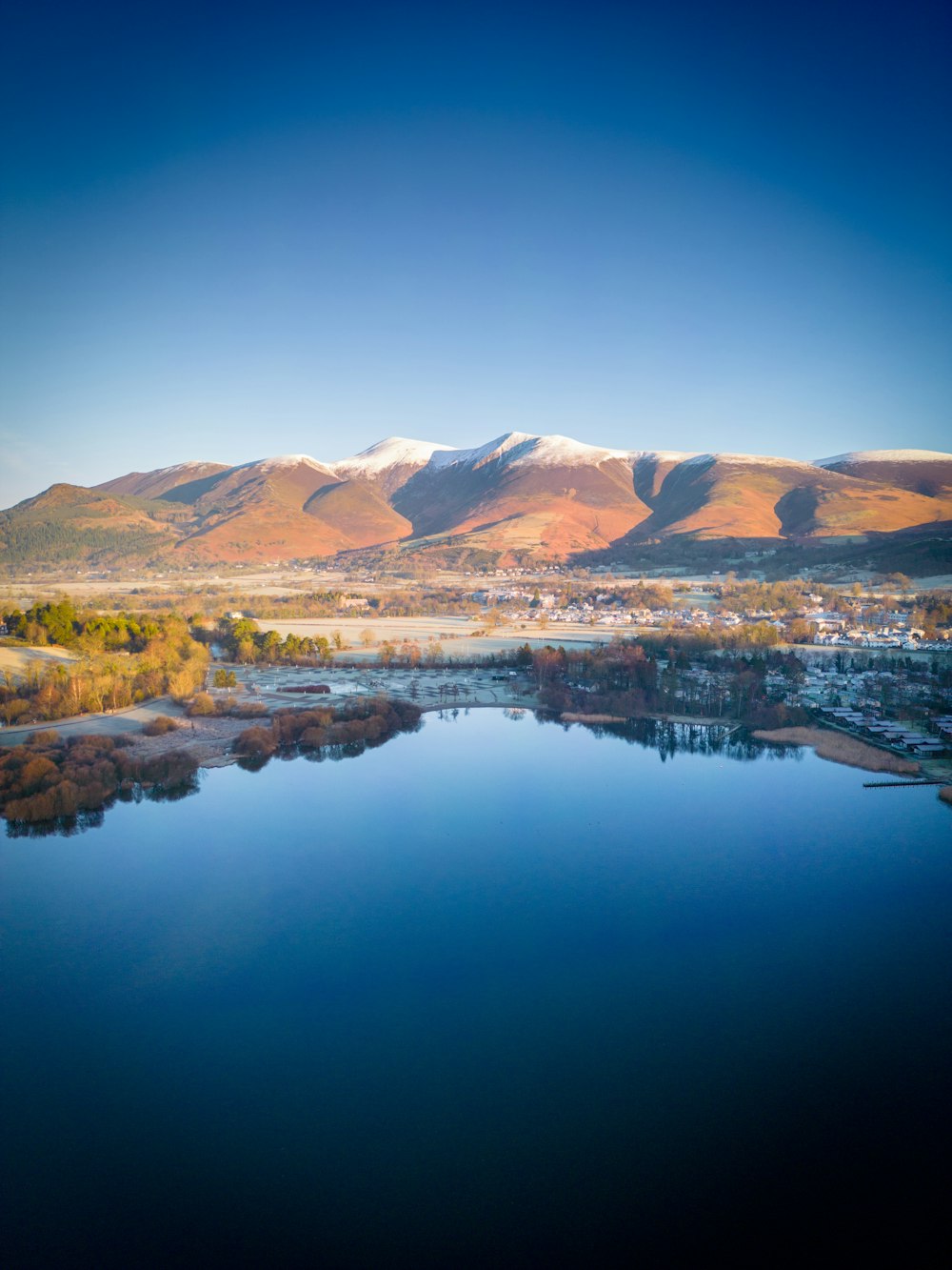 a lake surrounded by mountains in the middle of the day