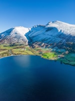 Snow-capped mountains and serene lakes in New Zealand under a clear blue sky.