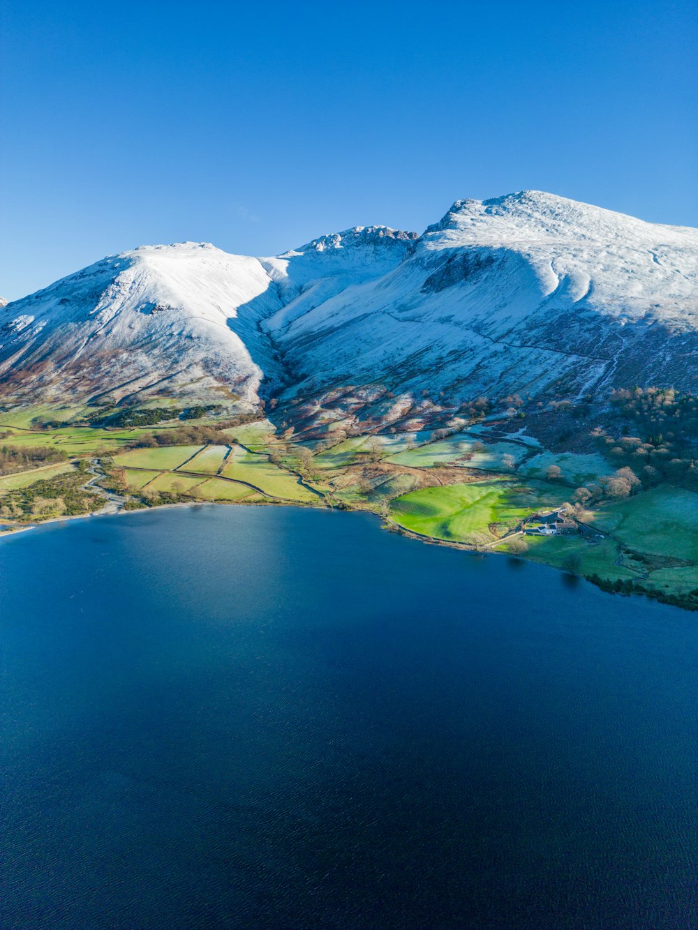 a large body of water surrounded by snow covered mountains