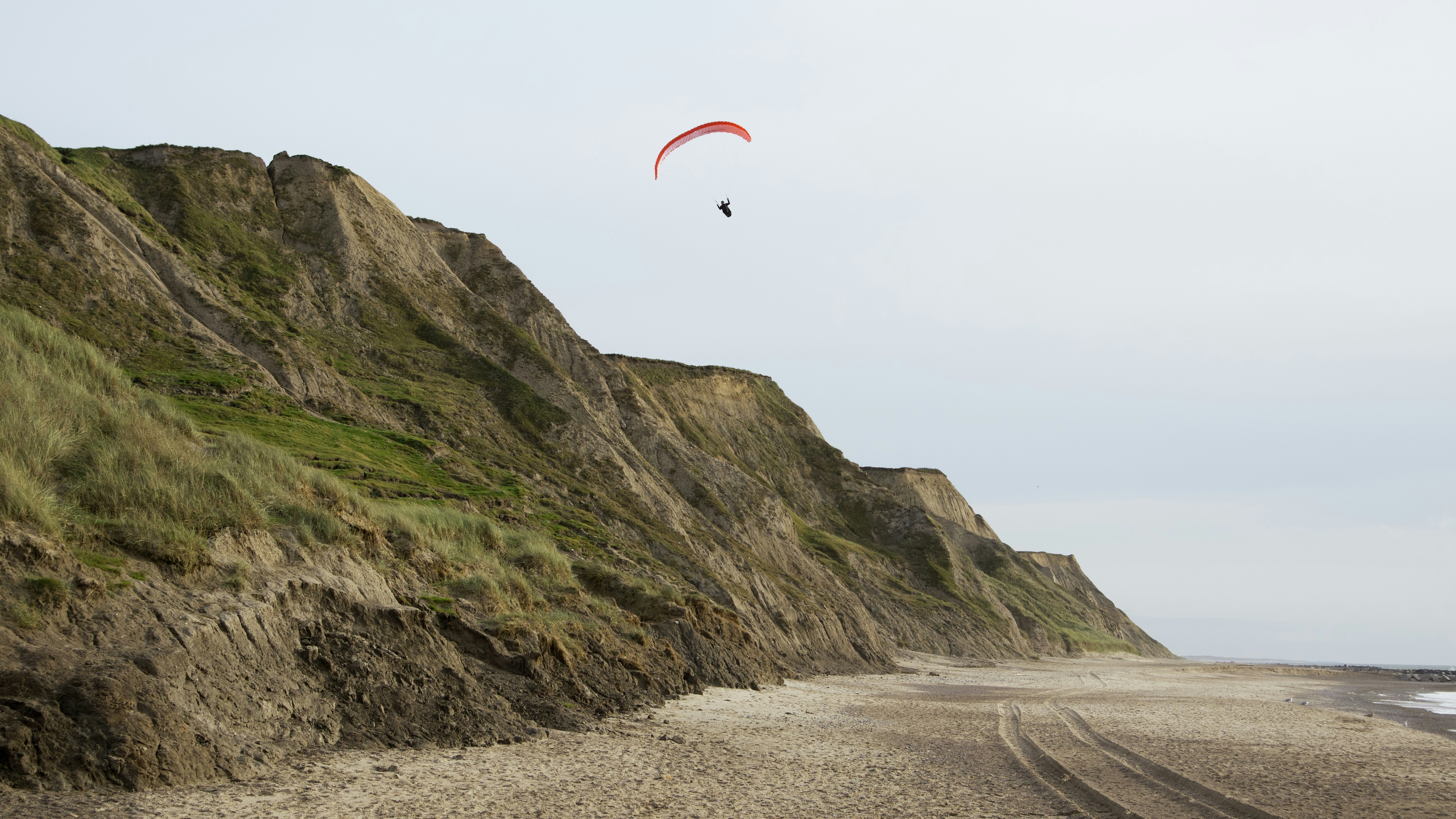 a person flying a kite over a sandy beach