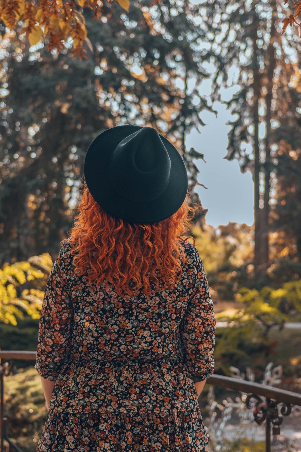 a woman with red hair wearing a black hat