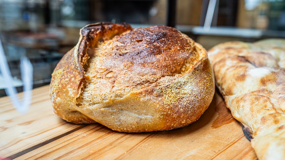 una pagnotta di pane seduta sopra un tagliere di legno