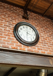 a clock mounted to the side of a brick building