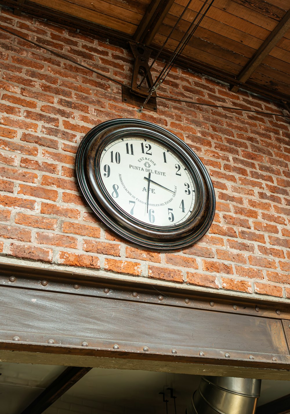 a clock mounted to the side of a brick building