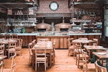 a restaurant with wooden tables and chairs and a clock