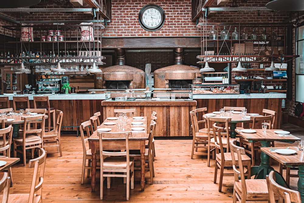 a restaurant with wooden tables and chairs and a clock