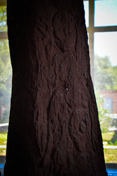 A towering broken stone monolith surrounded by mist and ancient glyphs, glowing faintly in low light.