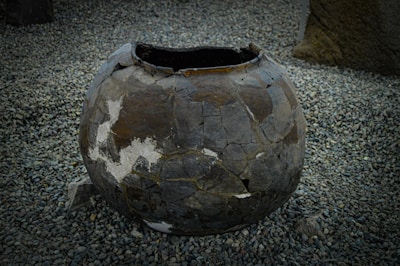 An ancient, weathered artifact glowing faintly with mysterious energy on a barren alien landscape.