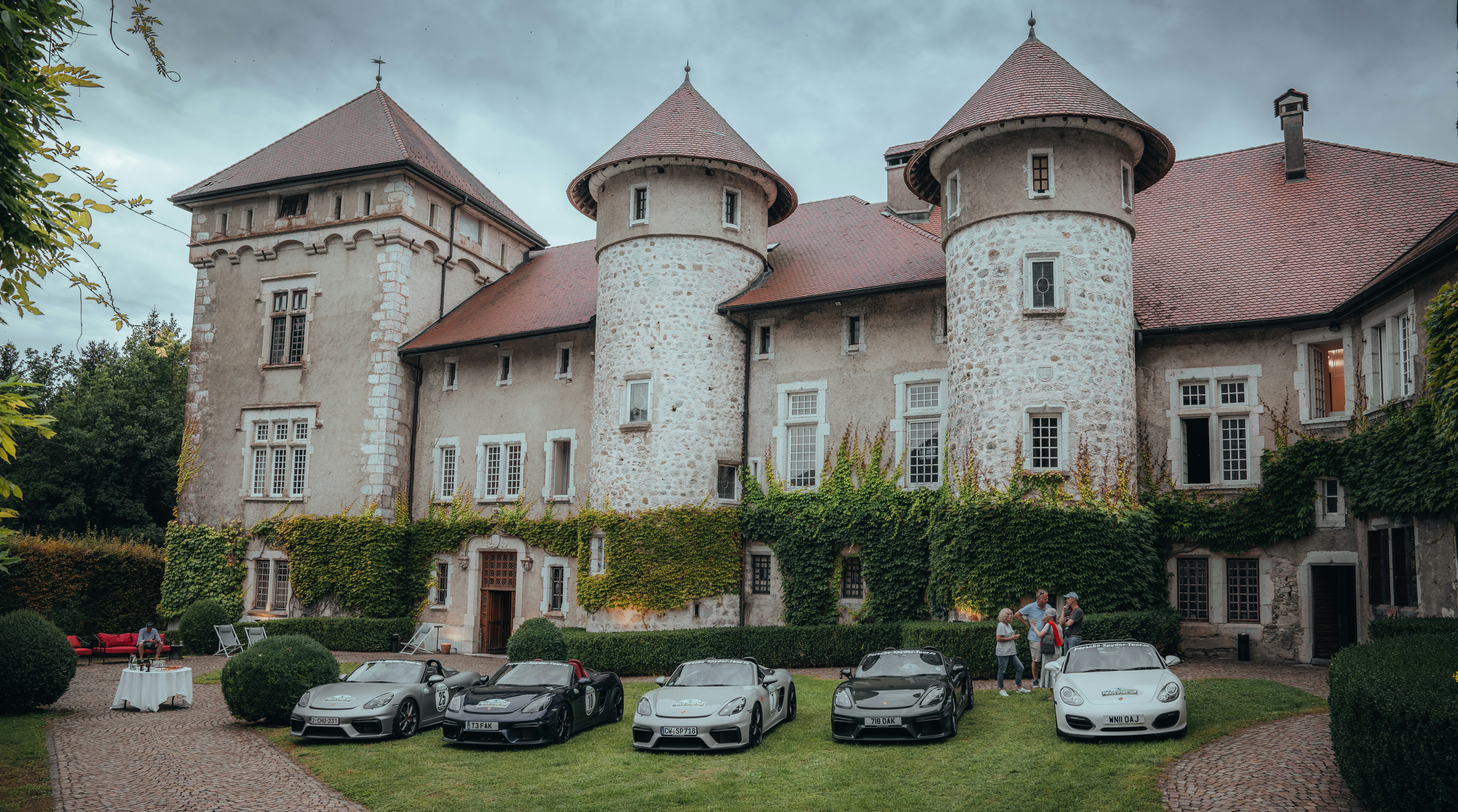 a group of cars parked in front of a castle