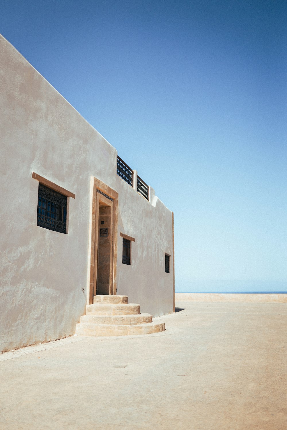 a white building with a door and steps leading to it