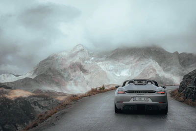 A sleek sports car speeding along a winding mountain road.