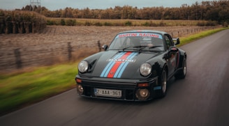 A powerful Aston Martin cruising down a coastal road.