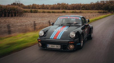 A powerful Aston Martin cruising down a coastal road.