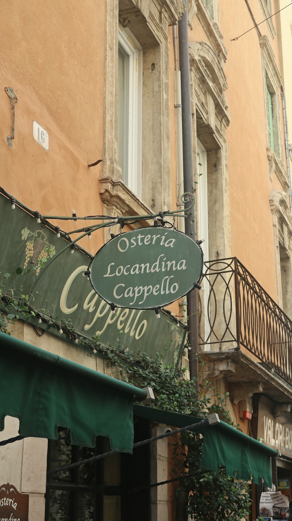 a building with a green awning and a sign for a cafe