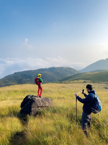 Portrait of Daniel and Joshua Gerritsen standing in a lush green Irish field with their cameras.