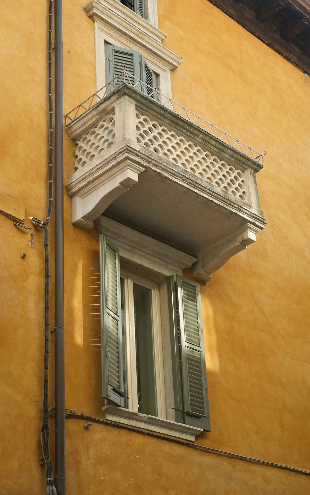 a tall yellow building with a balcony and balconies