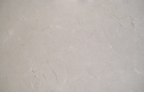 Close-up of polished marble slabs with natural veining under soft showroom lighting.