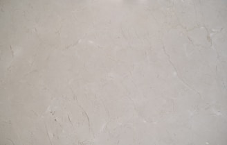 A close-up view of a light gray marble surface with natural veining and subtle variations in texture.