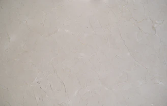 Close-up of a smooth marble slab with delicate gray veining under soft lighting