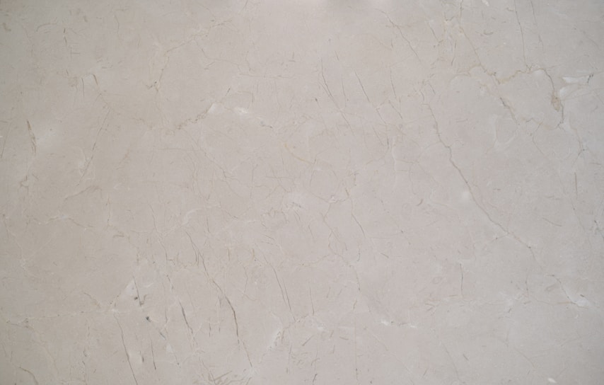 A sleek marble countertop with subtle gray veining, bathed in natural light.