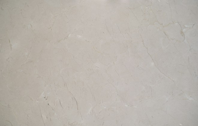 A close-up view of a light gray marble surface with natural veining and subtle variations in texture.