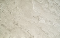 A close-up of luxurious cream textures spread out on a marble background.