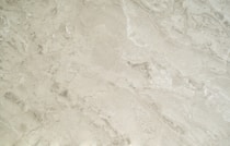 Close-up of a sleek marble countertop with subtle veining under soft lighting, highlighting its luxurious texture.