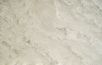 Close-up of polished marble slabs stacked neatly in a warehouse with warm lighting.