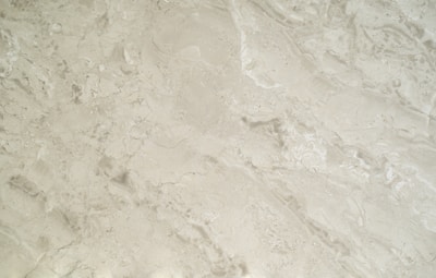 Close-up of a sleek marble countertop with subtle veining under soft lighting, highlighting its luxurious texture.