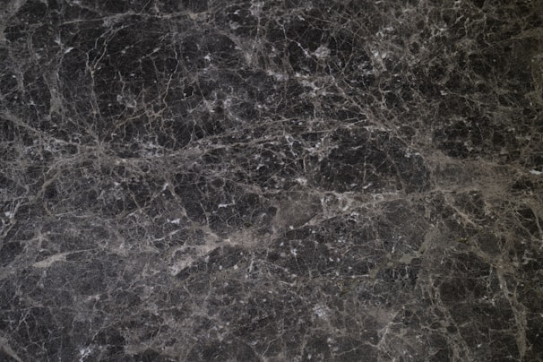 Minimalist black marble texture with subtle platinum highlights evoking precision and stability.