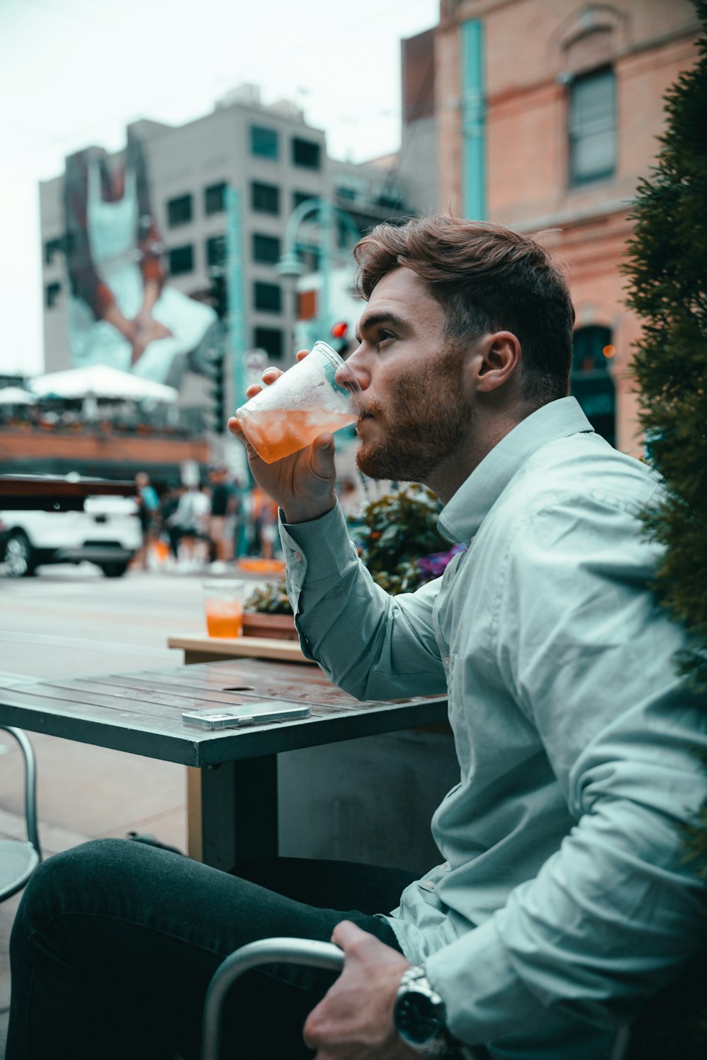 a man sitting at a table drinking from a bottle