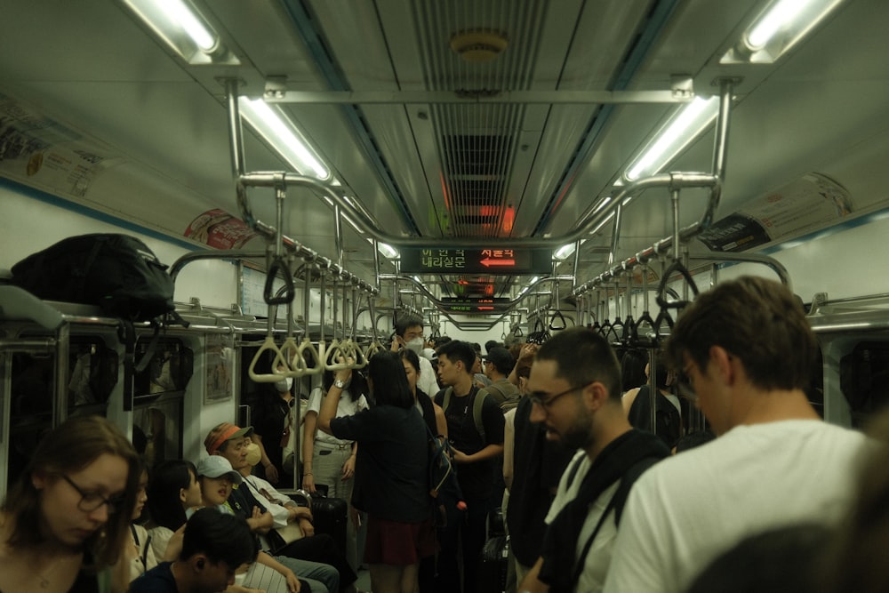 a group of people standing on a subway train