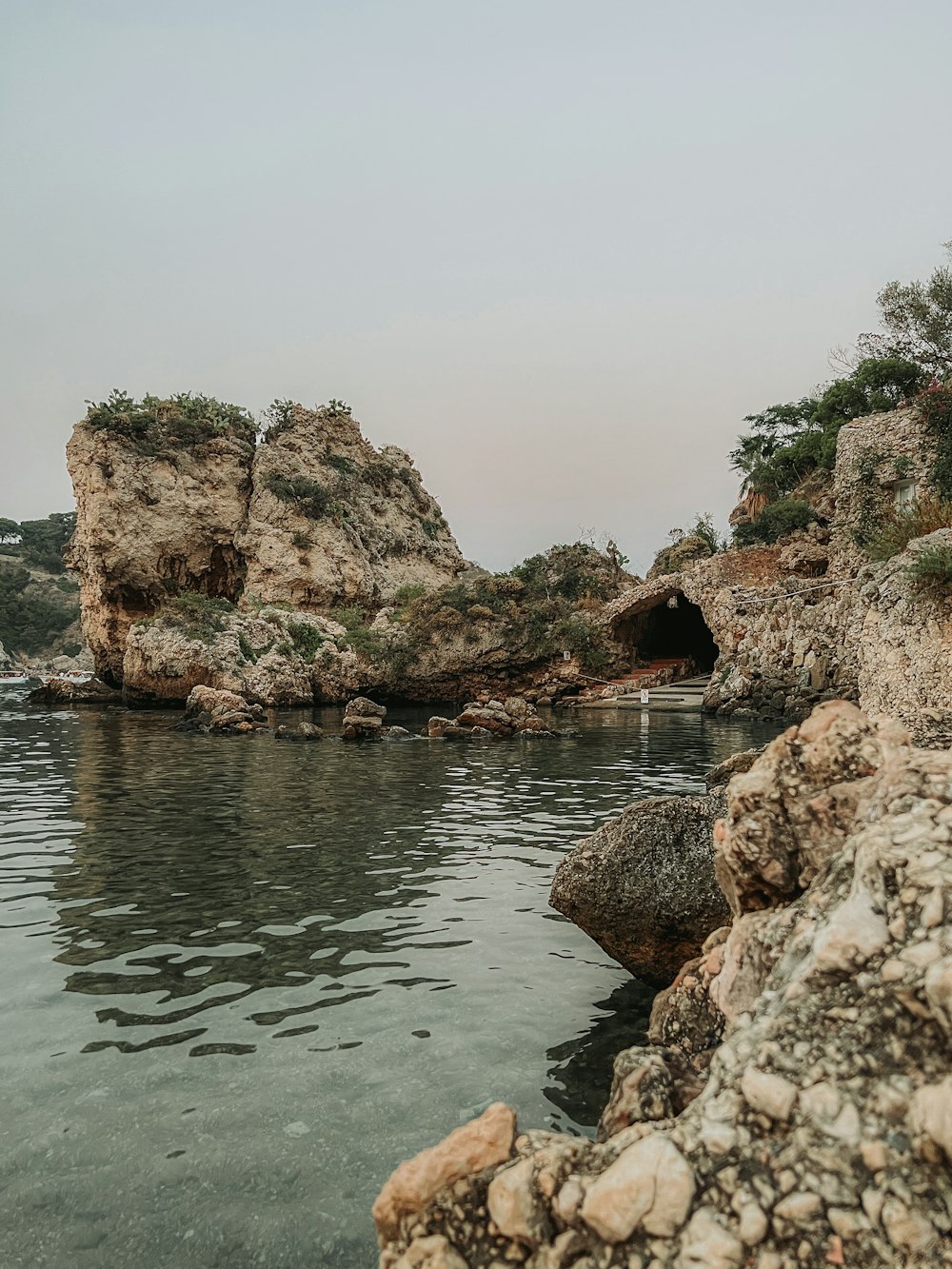 uno specchio d'acqua circondato da rocce e alberi