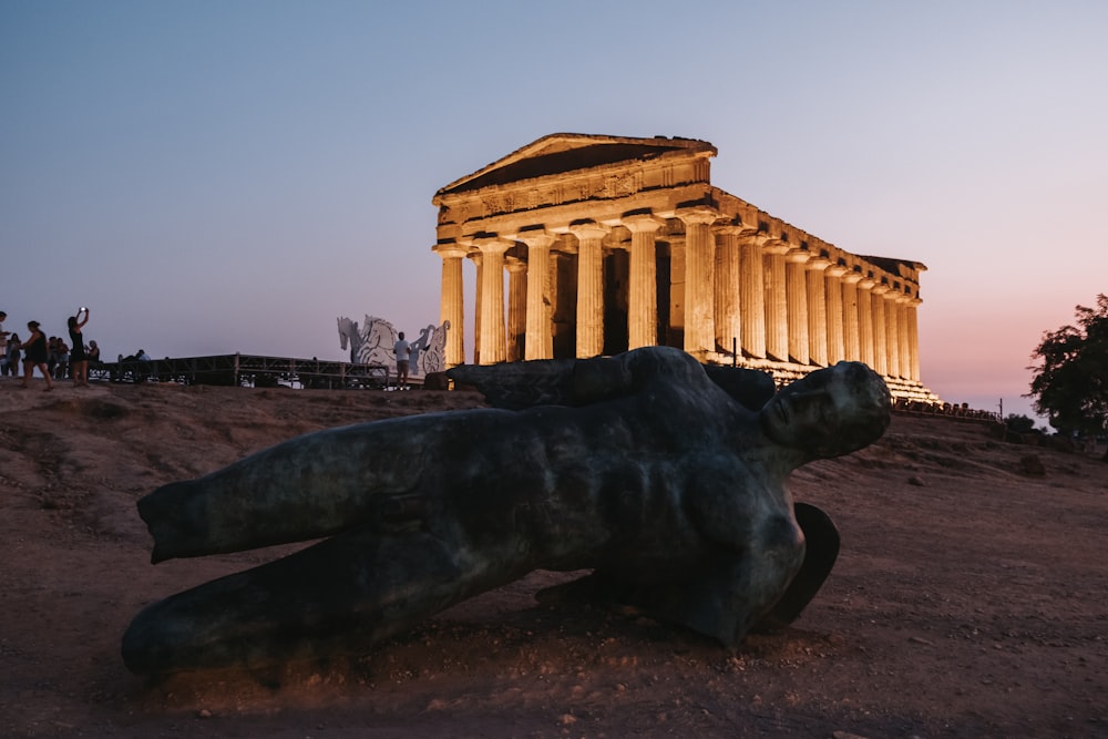 a statue of a bear laying in front of a building