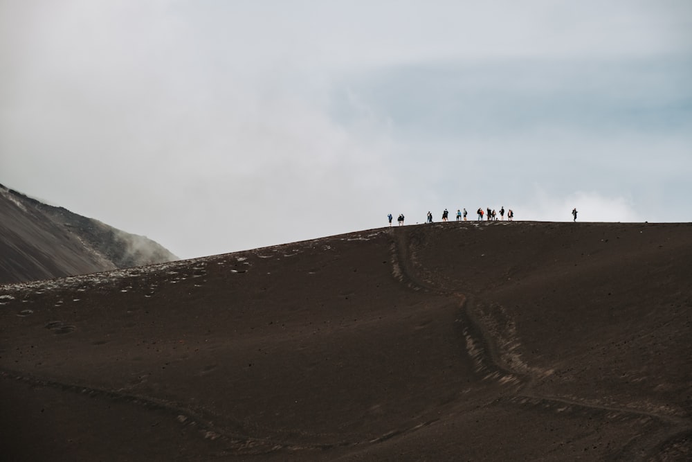 a group of people standing on top of a hill