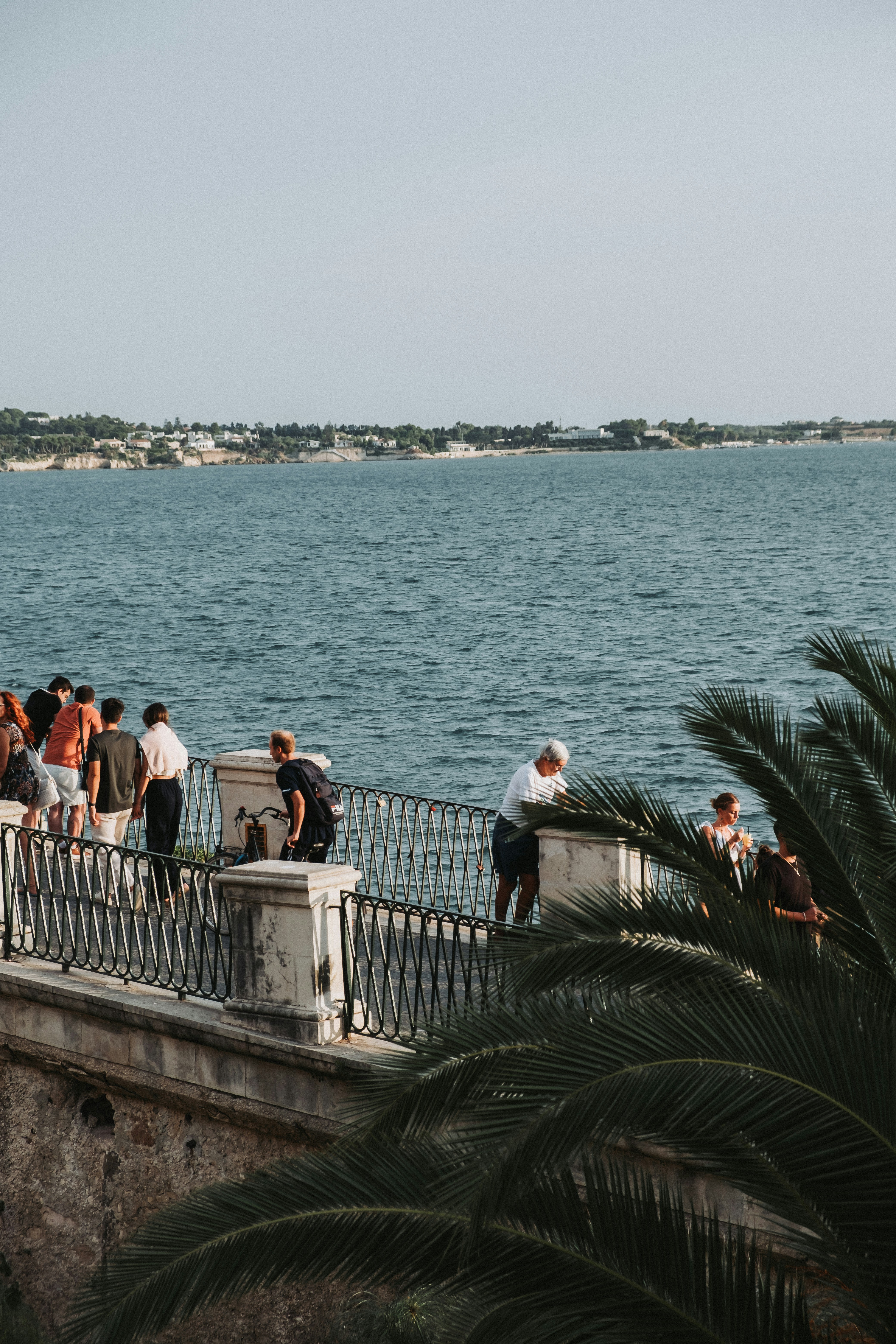 a group of people standing on top of a bridge next to a body of water