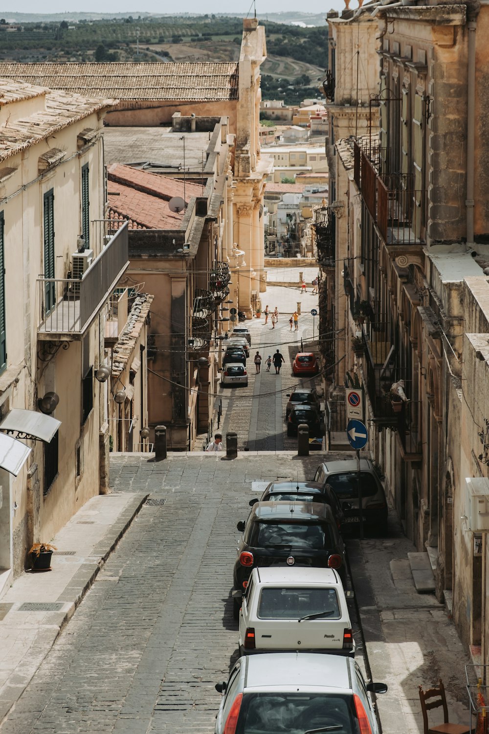 a street lined with parked cars next to tall buildings