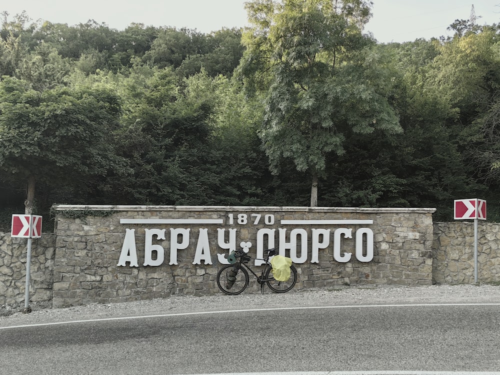 a bicycle parked in front of a stone wall