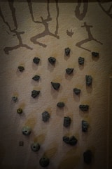 A textured wall blending earth tones and cultural motifs in a quiet urban space.