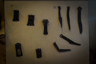 A collection of forged tools displayed on a dark surface.