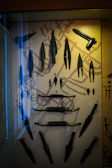 An array of hand-forged swords displayed like museum artifacts against a warhorse gray backdrop.